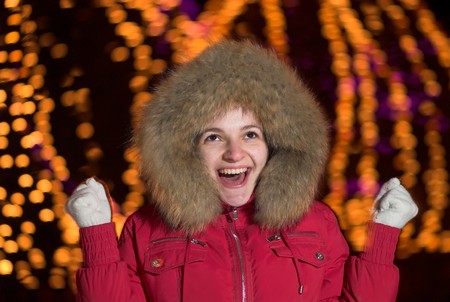 Young female is screaming. Defocused lights on background.の写真素材