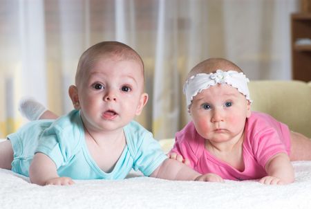 Two little babies is lying in bedの写真素材