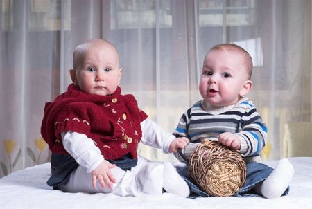 Two funny kids are sitting in bedの写真素材