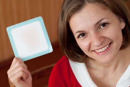 Smiling girl with empty card in her handの写真素材