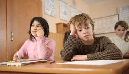 Thoughtful schoolchildren with head on theirs handsの写真素材