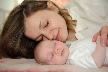 Young mother lying with her little baby