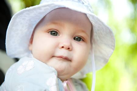 Cute baby in white Panama hat posing outdoors.の写真素材