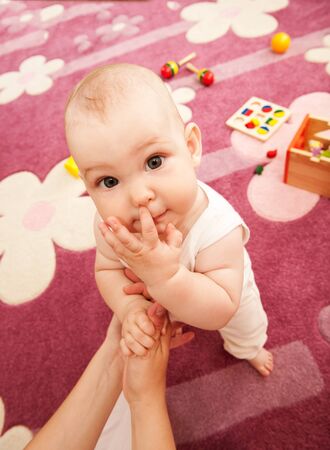 Young mother is playing with her baby n playroomの写真素材