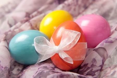 Colorfull vibrant Easter eggs with bow on textile background
