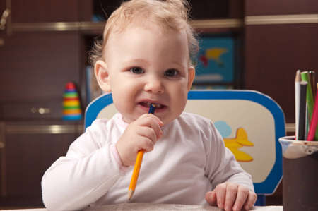 Little baby girl drawing with colorful pencils