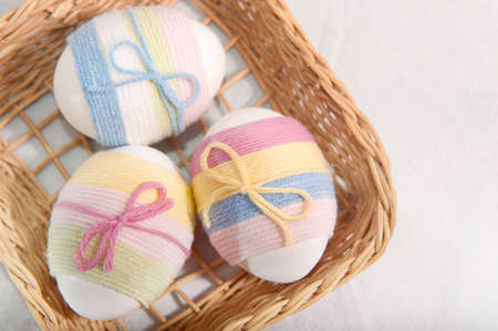 Three yarn wrapped Easter eggs in basket