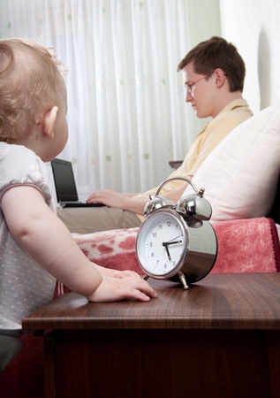 Young busy fathe r with laptop ingoring his little daughterの写真素材