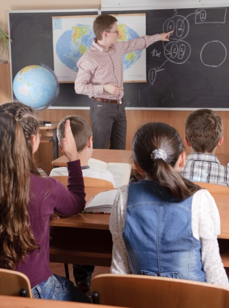 Male teacher in front of elementary age schoolchildren.の写真素材