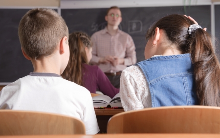 Young male teacher in front of classの写真素材