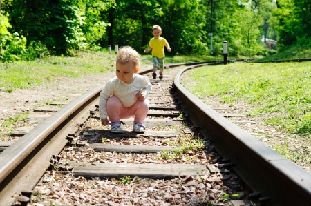 Little boy and his little sister plauing at railroadの写真素材