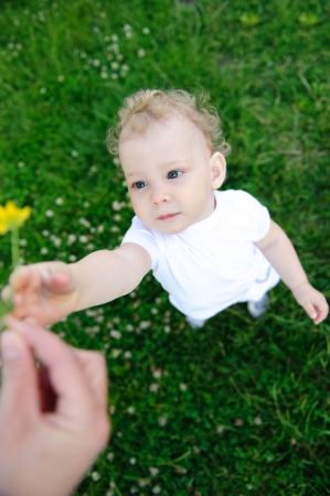 Mother is giving a flower to her little daughterの写真素材