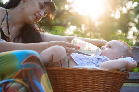 Young mother feeding her sun in the parkの写真素材