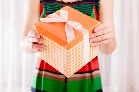 Young girl holding present box with ribbon bowの写真素材