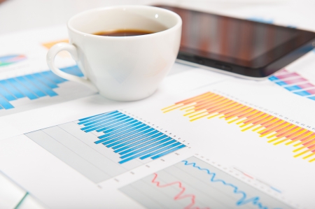 Desktop with lots of paperwork, tablet PC and a cup of fresh coffee. Business concept.の写真素材