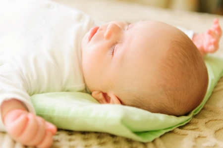 Cute newborn baby sleeping in bed. Shallow depth of field.の写真素材