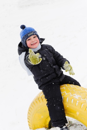 Little boy playing outdoors in snow. Showing thumb upの写真素材