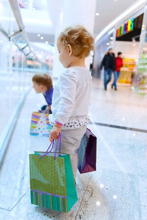 Two cute children with bags in mallの写真素材
