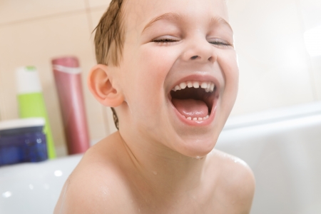 Happy little boy bathing in bathtub at homeの写真素材