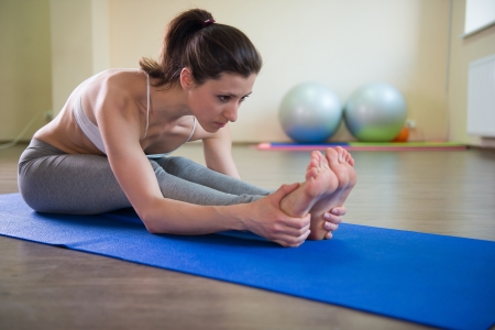 Young pretty girl stretching legs. Yoga workoutの写真素材