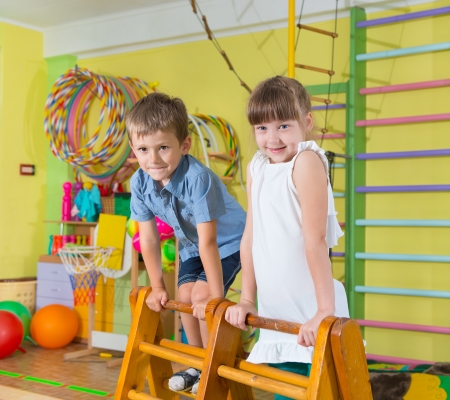 Cute children playing in kindergarten gymの写真素材