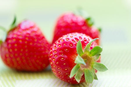 Juicy ripe strawberries against natural green backgroundの写真素材