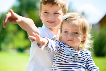 Little brother and sisiter playing in gardenの写真素材