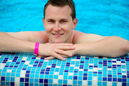 Young man portrait at swimming pool during vacation