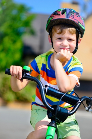 Cute little boy in helmet riding bicycleの写真素材