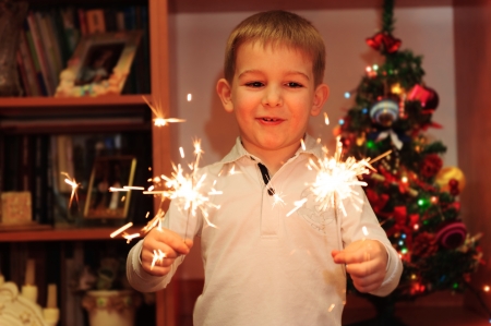 Cheerful little boy watching firework, sparklers with Bengal fire in handsの写真素材