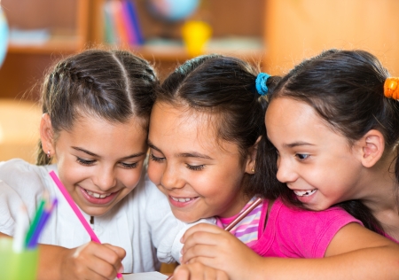 Group of cute schoolchildren drawing and having fun in classroomの写真素材