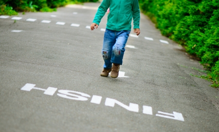 Little boy running on footpath to the finish lineの写真素材