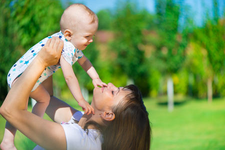 Young mother holding her little son at parkの写真素材