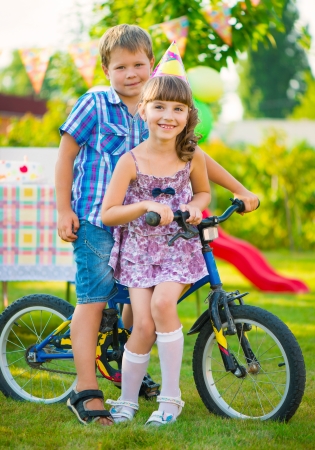 Two happy children in love sitting on bicycleの写真素材