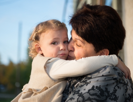 Cute little girl embracing with grandmotherの写真素材