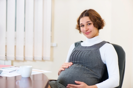Young pregnant woman working at officeの写真素材