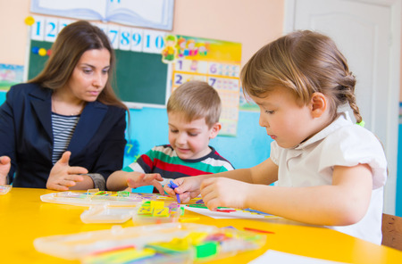 Cute little children having applique lesson at kindergartenの写真素材