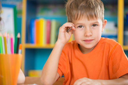 Cute little boy at lesson at junior schoolの写真素材