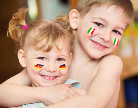 Cute little brother and sister with European flags on cheeksの写真素材