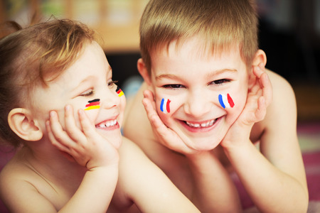 Cute little brother and sister with European flags on cheeksの写真素材