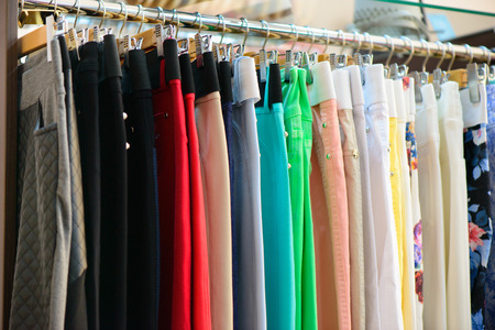 Variety of clothes hanging on rack in boutiqueの写真素材