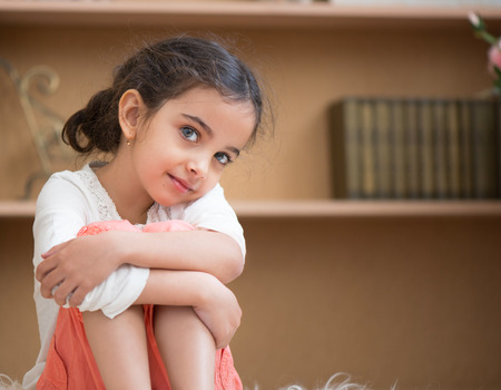 Portrait of cute little hispanic girl sittin on carpet at homeの写真素材