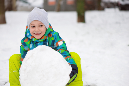 Children throwing snowballs in snowy winter parkの写真素材