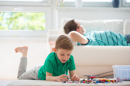 Little clever boy play with blocks, father ist at backgroundの写真素材