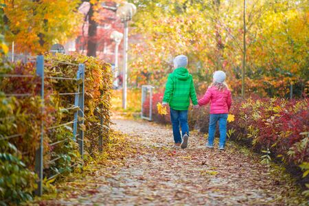 Two cute children walking in autumn townの写真素材
