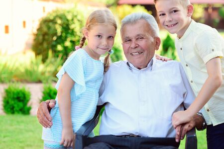 Portrait of happy old grandfather and cute children in summerの写真素材