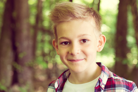 Portrait of an attractive young teenager in a plaid shirt in the schoolyardの写真素材