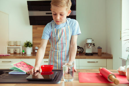 Portrait of young boy preparing chocolate cookies at modert kitchenの写真素材
