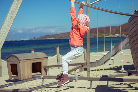 Portrait of adorable little girl playing at playground on a beachの写真素材
