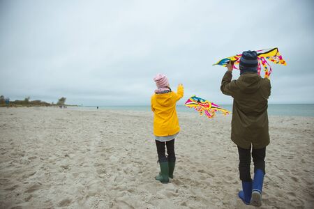 Teen brother and sister playing with kites in sand dunes of Baltic coastline in nothern Germanyの写真素材